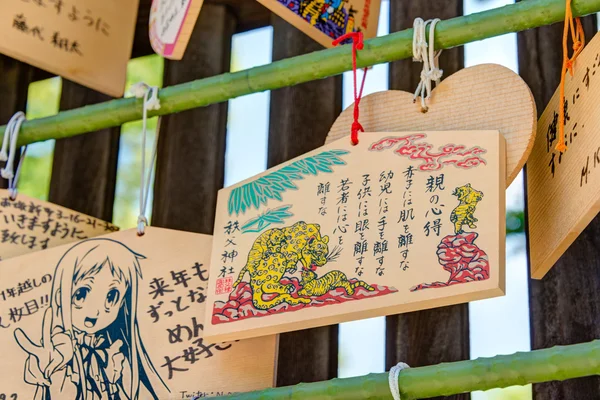 CHICHIBU, JAPÓN - 26 DE ABRIL DE 2014: Tablas de oración de madera en un Santuario Chichibu. Rezar por la felicidad, la buena vida, la salud, la paz, la suerte por escribir la palabra de oración en tableta de madera . — Foto de Stock