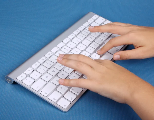 A girl writes on PC keyboard — Stock Photo, Image