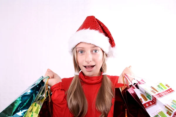 Begeistertes Mädchen als Weihnachtsmann mit Einkaufstaschen — Stockfoto