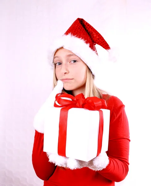 Träumendes, junges Mädchen als Weihnachtsmann mit einem Geschenk — Stockfoto