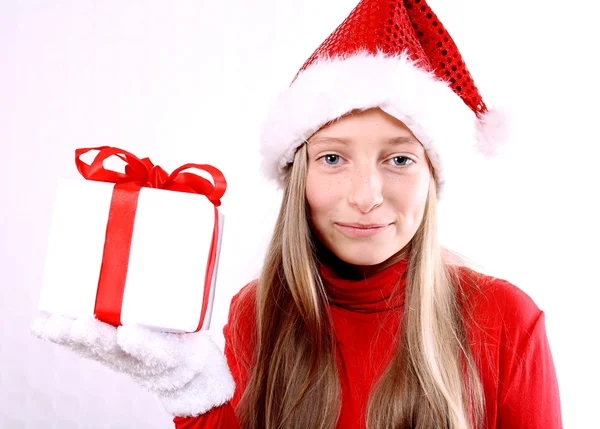 Menina como a Sra. Santa em vermelho pesa um presente — Fotografia de Stock