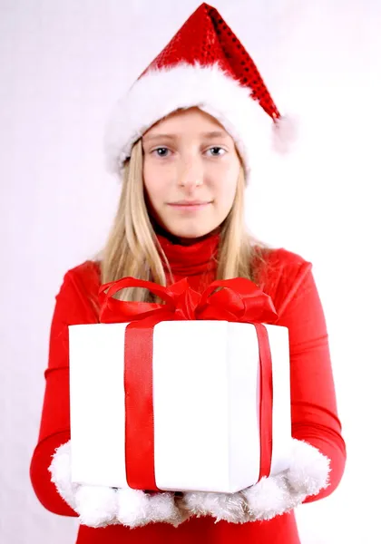 Young girl as Mrs. Santa gives a gift — Stock Photo, Image