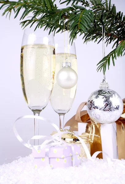 Bola de plata de Año Nuevo en una rama de árbol de Navidad con regalos y champán —  Fotos de Stock