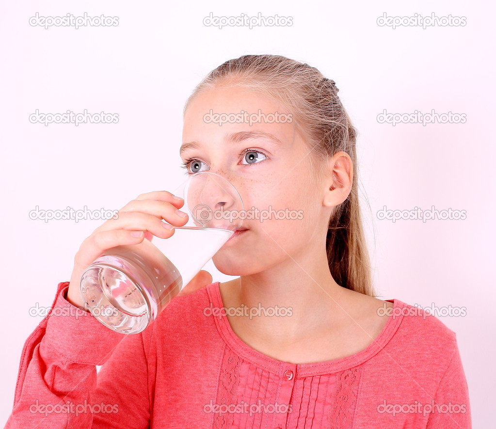 Girl in pink drinks water from a glass