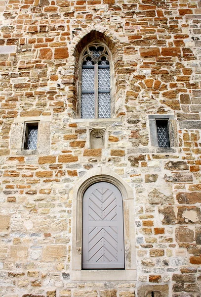 Fachada da igreja velha de tijolo e janela com porta — Fotografia de Stock