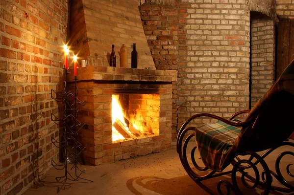 Chaise à bascule près de la cheminée et avec des bougies — Photo