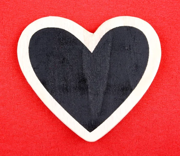 Board in heart shape on red background for message — Stock Photo, Image