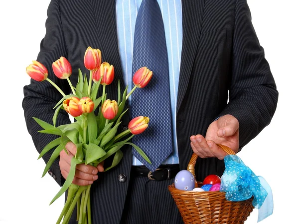 Homme d'affaires avec tulipes et panier en osier plein d'œufs de Pâques — Photo