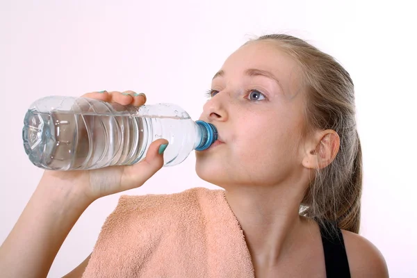 Blonde girl in drinking water after exercise — Stock Photo, Image