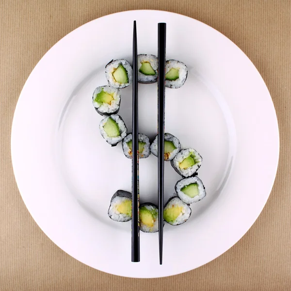 Sushi como signo del dólar en el plato blanco, primer plano —  Fotos de Stock