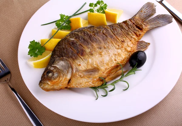 Fried fish on white plate with knife and fork — Stock Photo, Image