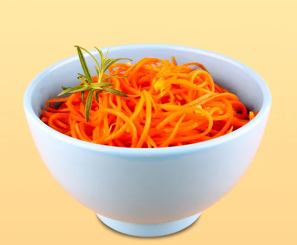 Salada de cenoura em tigela azul no fundo amarelo — Fotografia de Stock