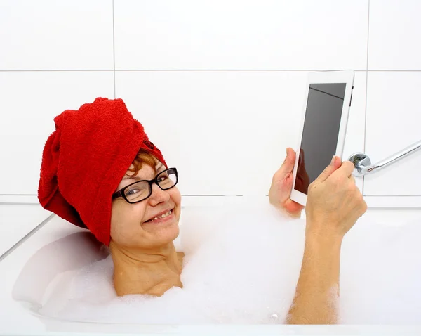 Mujer sonriente en la bañera con tabletas —  Fotos de Stock