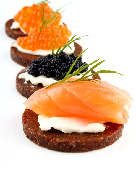 Zwart brood met zalm vissen, forel en steur kaviaar — Stockfoto