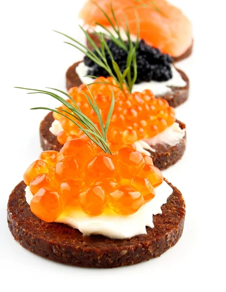 Pâine neagră acoperită cu somon, păstrăv, caviar de sturion și pește — Fotografie, imagine de stoc