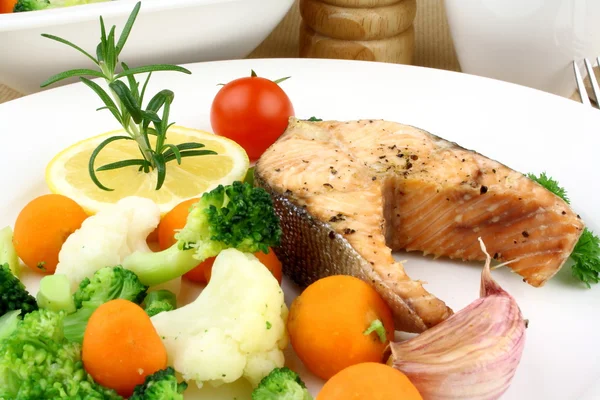 Bife de salmão grelhado e legumes em prato branco — Fotografia de Stock