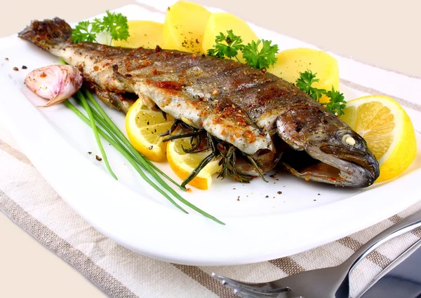 Gegrilde hele forel met aardappel, citroen en knoflook — Stockfoto