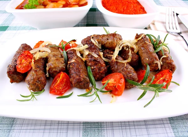 Grilled cevapcici with ajvar and giant white beans — Stock Photo, Image