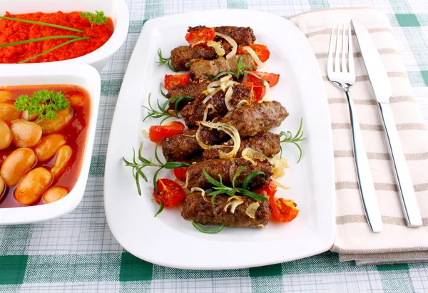 Grilled cevapcici with ajvar and giant white beans — Stock Photo, Image