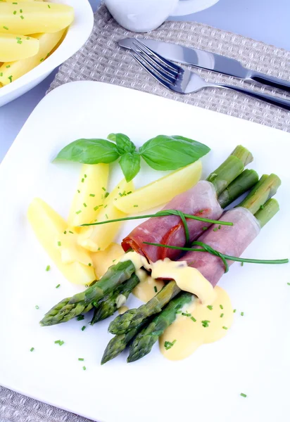 Grüner Spargel mit Schinkenkartoffeln, Basilikum und Sauce — Stockfoto