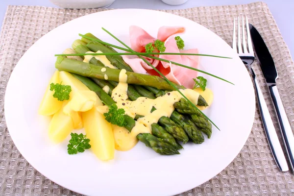 Grön sparris med parmaskinka, potatis, persilja och sås — Stockfoto