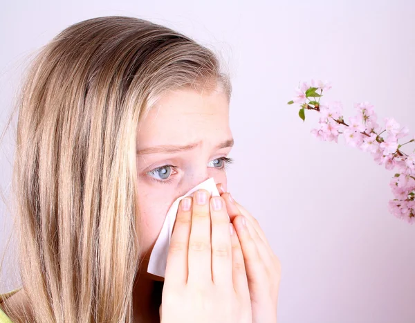 Girl blows her nose with handkerchief and cherry blossoms — Stock Photo, Image