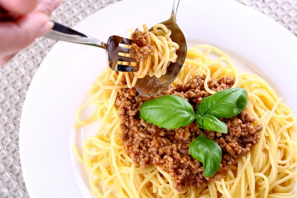 Comer adequadamente espaguete bolonhesa com garfo e colher — Fotografia de Stock