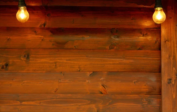 Старая деревянная доска с двумя лампочками на заднем плане — стоковое фото