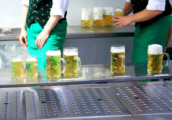 Fresh draft beer at Oktoberfest and two worker — Stock Photo, Image