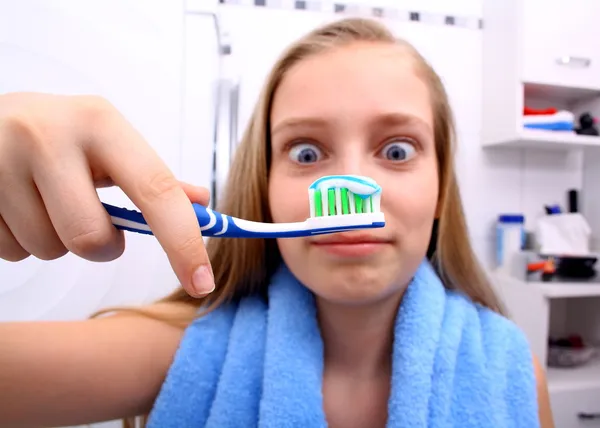 Blonde girl is surprised when brushing your teeth — Stock Photo, Image