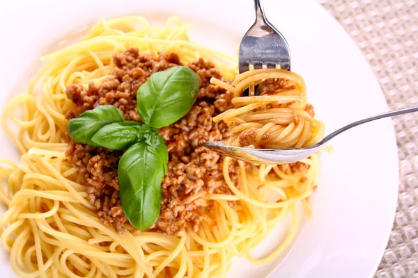 Eat spaghetti bolognese with spoon and fork, soft focus — Stock Photo, Image