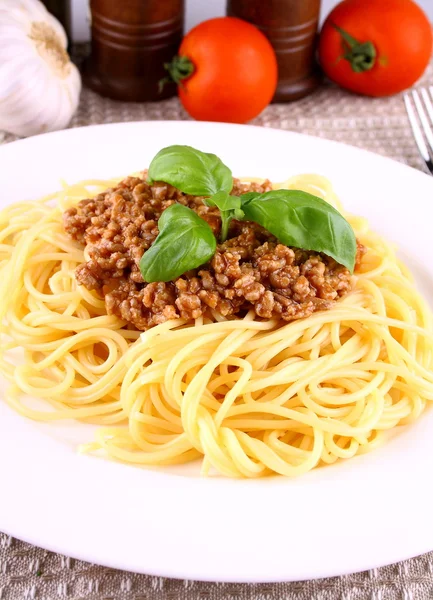 Pyszne spaghetti bolognese z bazylią liści na białym talerzu — Zdjęcie stockowe