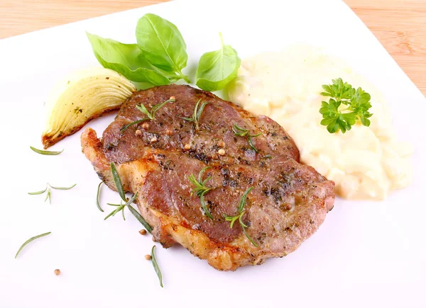 Grilled steak meat with onion, potato salad and basil — Stock Photo, Image
