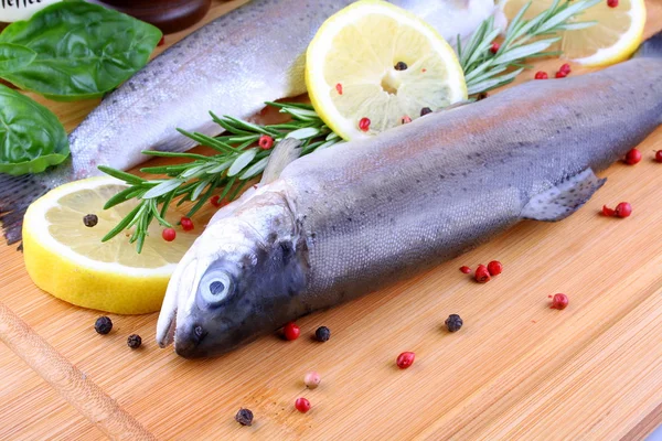 Two fresh whole trout with species on bamboo board — Stock Photo, Image