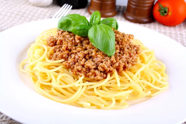 Bolonhesa de espaguete com manjericão na placa branca — Fotografia de Stock