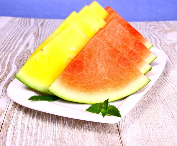 Rote und gelbe Wassermelone mit Minze auf weißem Teller — Stockfoto