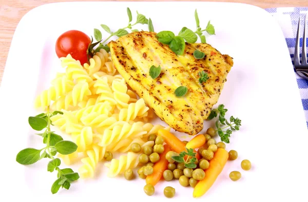 Bife grelhado de aves com macarrão, verde-ervilha, cenouras — Fotografia de Stock