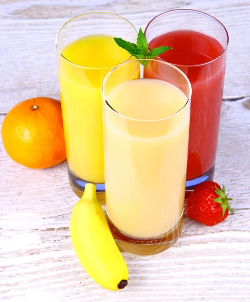 Бананы, апельсины и клубничный сок в стакане — стоковое фото