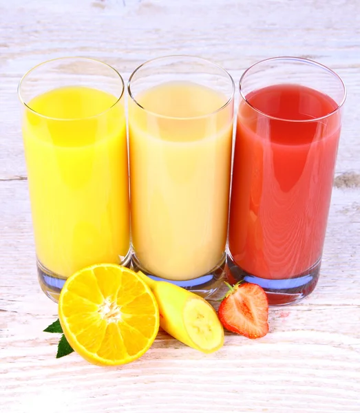 Бананы, клубника и апельсины ломтик, сок в стакане — стоковое фото