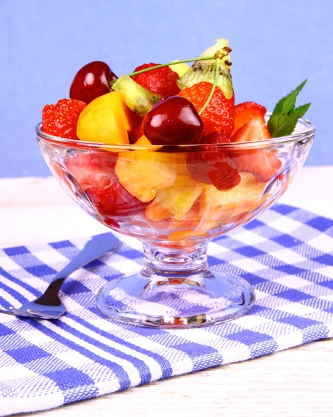 Fruits salad in glass bowl and dessert fork — Stock Photo, Image