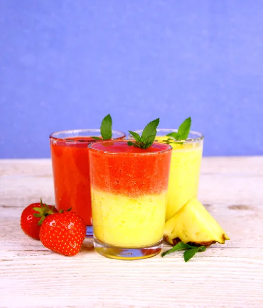 Batido de fresa y piña mezclado sobre fondo azul —  Fotos de Stock