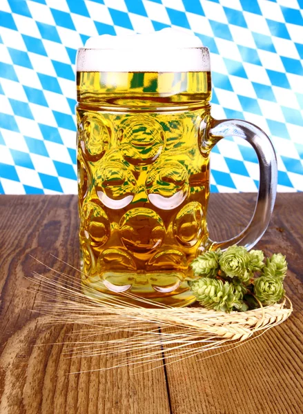 Cerveja bávara, trigo e lúpulo sobre fundo de madeira — Fotografia de Stock