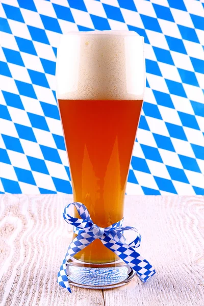 Wheat beer in glass with blue-white ribbon, checkered — Stock Photo, Image