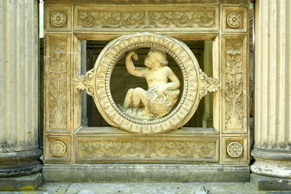 Antique sculpture of an angel, boy with grapes — Stock Photo, Image