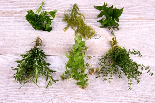 Herbs in bundle on white wooden background — Stock Photo, Image