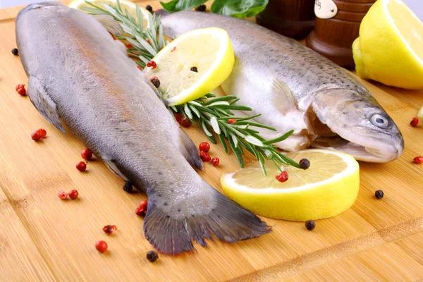 Due trote arcobaleno intere con spezie, peperoncino e limone — Foto Stock