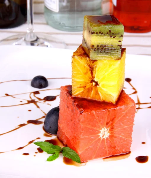 Grapefruit, kiwi and orange dessert with chocolate sauce — Stock Photo, Image