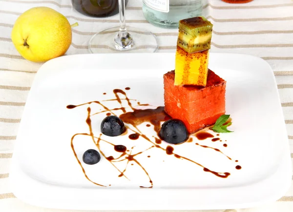 Grapefruit, kiwi and orange cubes with chocolate sauce — Stock Photo, Image