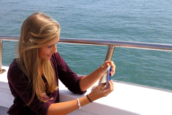 Happy blond girl with phone on the boat — Stock Photo, Image