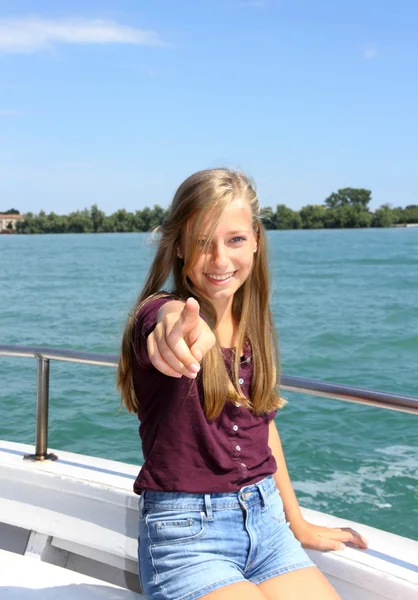 Joyeux jeune fille blonde montre cible sur le navire en mer — Photo